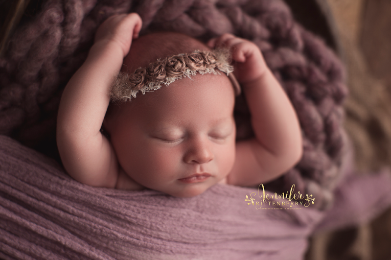newborn infant posed on purple blanket